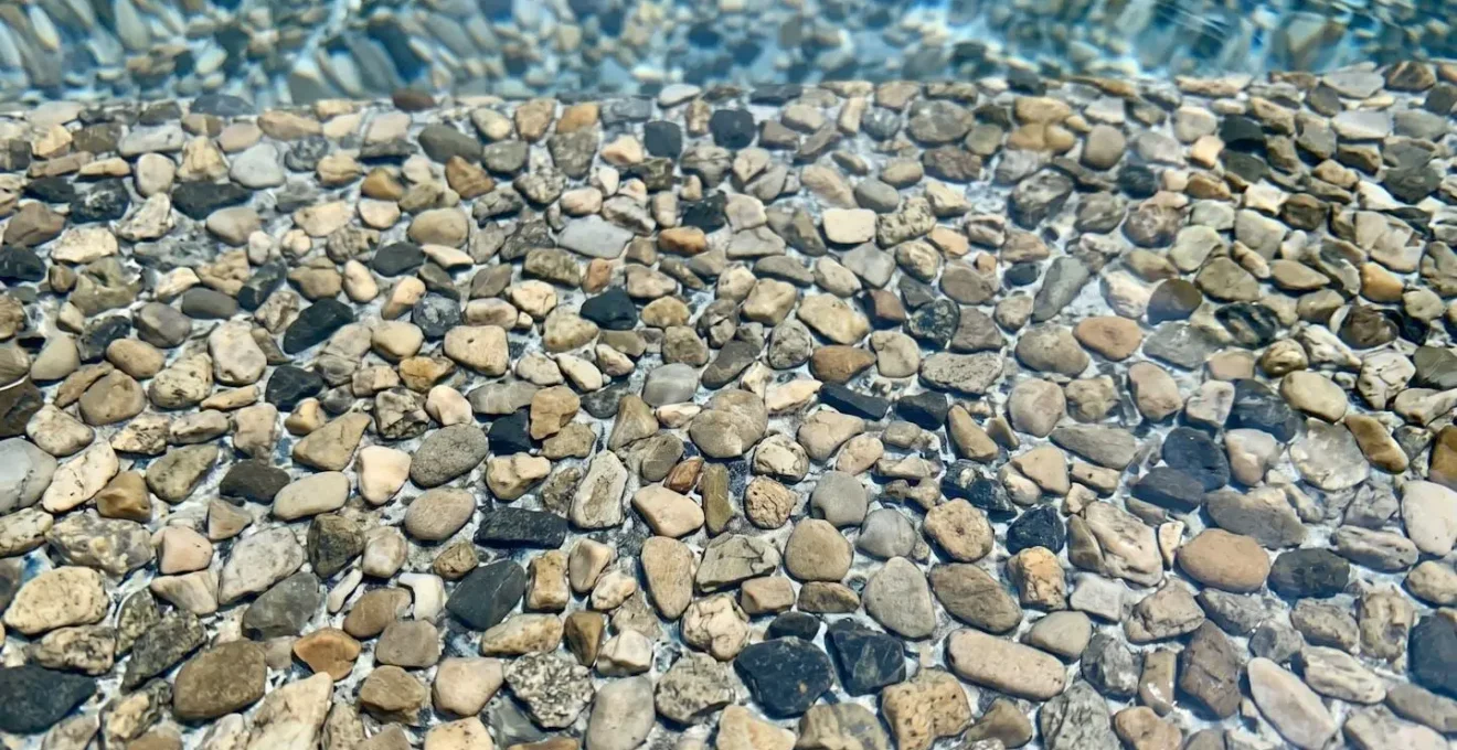 Gros plan d'un liner à motif galet, avec des reflets d'eau.